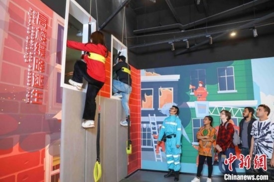 5月9日，留學生體驗模擬高樓緩降逃生。張鷹 攝