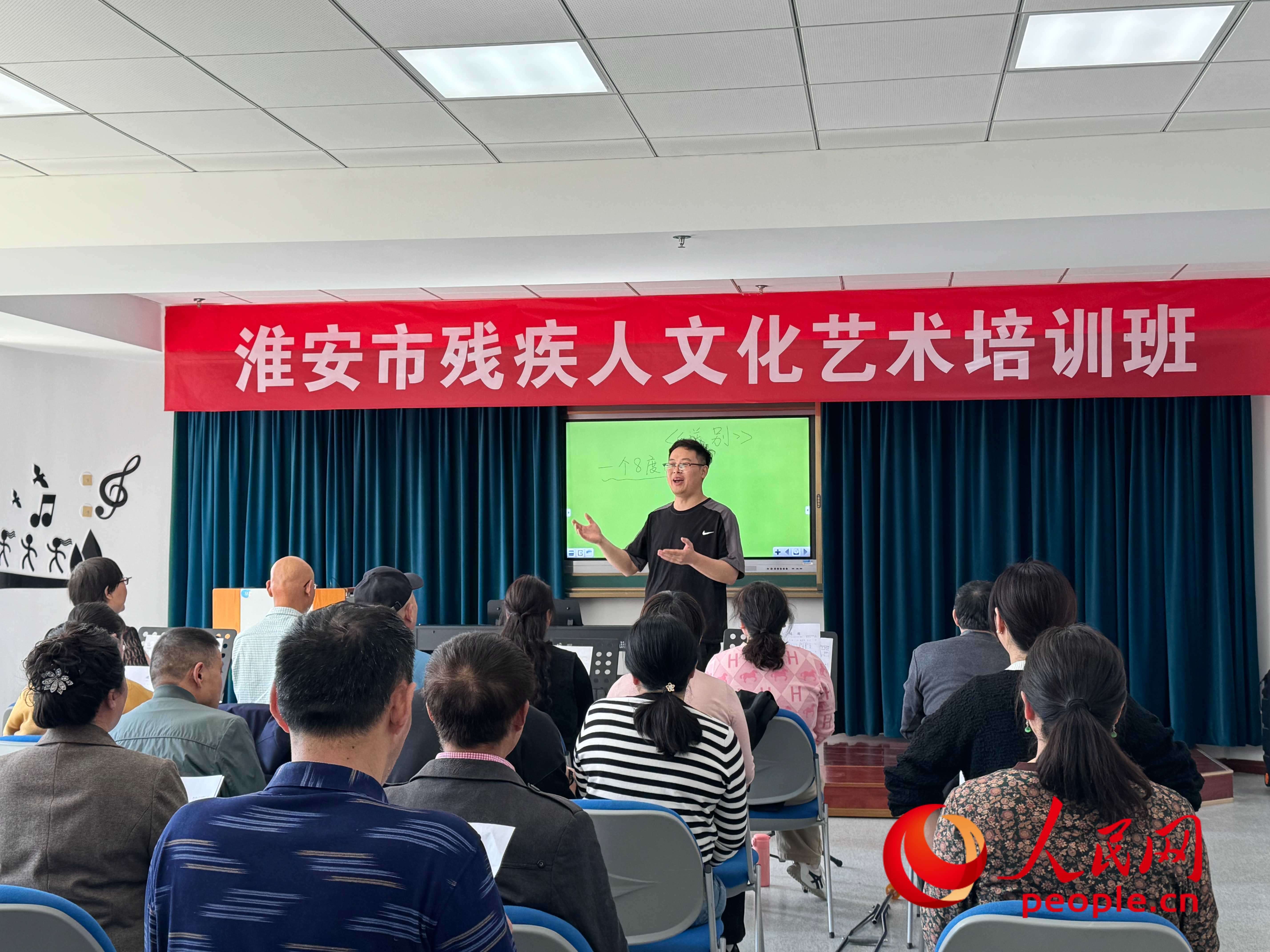 在淮安市殘疾人文化藝術(shù)培訓(xùn)班上，聲樂老師在教殘疾人唱《送別》這首歌曲。人民網(wǎng) 周靜圓攝
