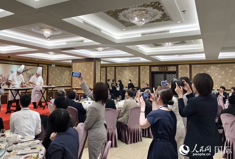 國家級非物質(zhì)文化遺產(chǎn)、全聚德片鴨工藝吸引代表團成員拍照留念。