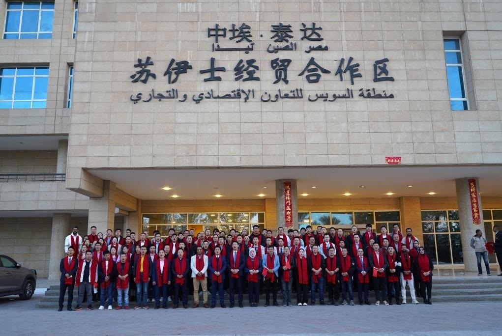 2024年2月11日，在位于埃及蘇伊士省的中?！ぬ┻_蘇伊士經(jīng)貿(mào)合作區(qū)，中埃員工在合作區(qū)辦公大樓前合影拜年。新華社發(fā)（泰達合作區(qū)供圖）