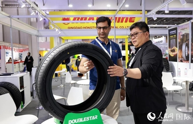 工作人員向客戶展示雙星電動汽車輪胎。和傳統(tǒng)汽車輪胎相比，電動汽車輪胎具有更高承載能力、更加靜音舒適、更好極速抓地、更低滾動阻力等特點。人民網(wǎng)記者 管克江攝