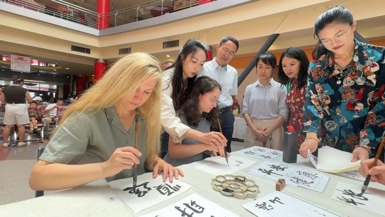 羅馬尼亞友人在活動(dòng)現(xiàn)場(chǎng)學(xué)寫漢字。中國駐羅馬尼亞大使館領(lǐng)僑處供圖