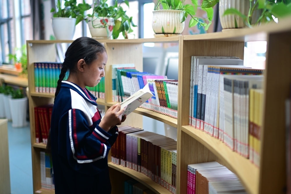 6月18日，果洛西寧民族中學(xué)學(xué)生尼東拉毛在圖書室看書。