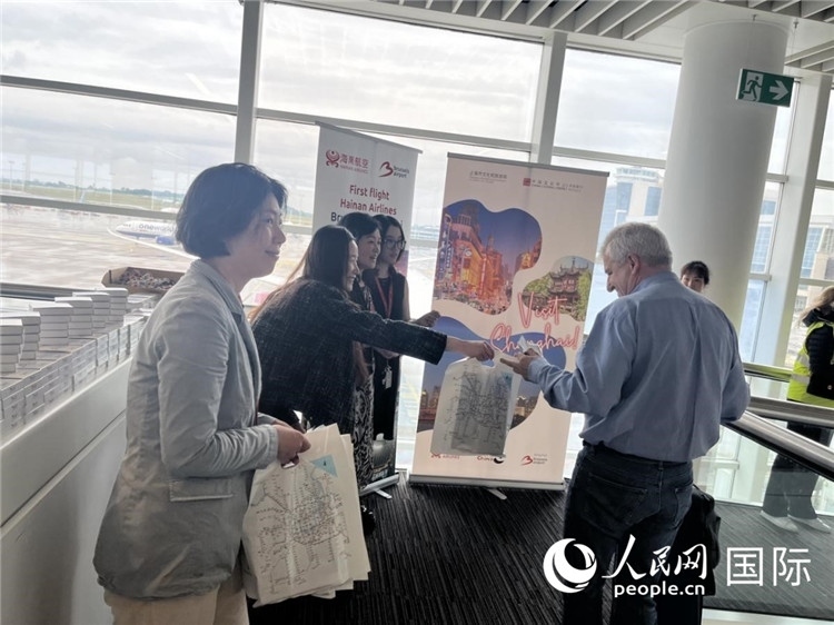 圖為工作人員向乘客發(fā)放復(fù)航首班禮物。 牛瑞飛攝