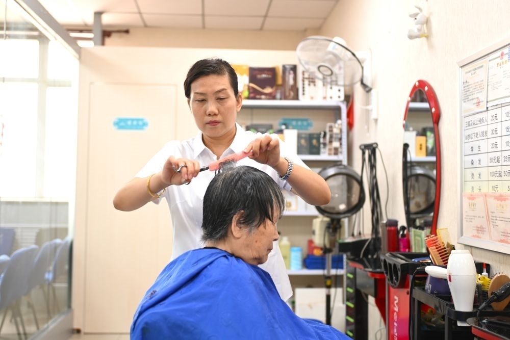6月20日，長(zhǎng)城花園社區(qū)的志愿者為居民理發(fā)。