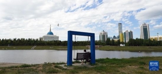 6月30日，一名女子在哈薩克斯坦首都阿斯塔納伊希姆河畔休息。新華社記者 王建華 攝