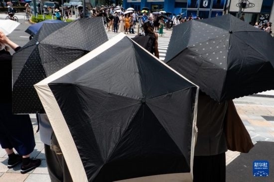 7月4日，人們在日本東京原宿的街道上等待紅綠燈。新華社記者 張笑宇 攝