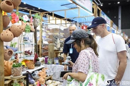 游客在蘭納博覽會(huì)特色展位上選購工藝品。人民網(wǎng)記者楊一攝