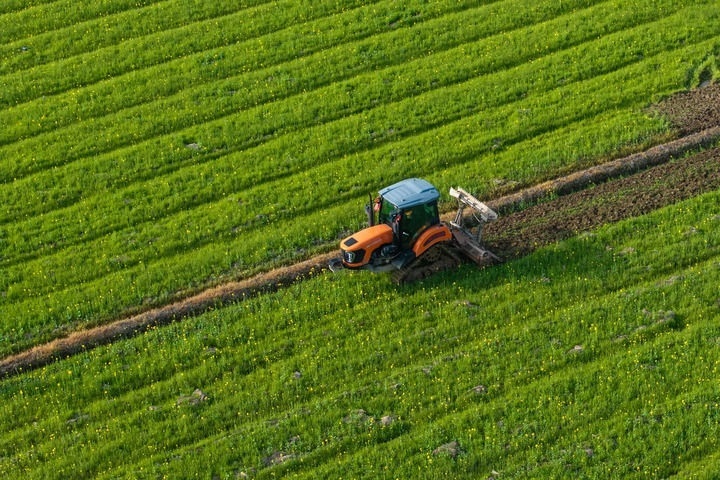2024年3月19日，在湖南省常德市鼎城區(qū)謝家鋪鎮(zhèn)港中坪村，村民駕駛農(nóng)機(jī)翻耕田地（無人機(jī)照片）。新華社記者 陳思汗 攝