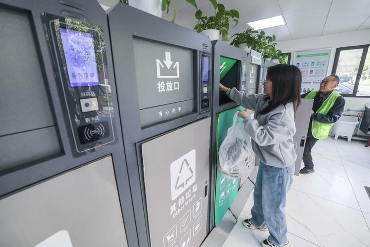 2024年4月10日，在浙江省湖州市吳興區(qū)飛英街道新華府小區(qū)內(nèi)，居民在垃圾分類智能系統(tǒng)的指導(dǎo)下進(jìn)行垃圾分類投放，居民的投放情況將實(shí)時(shí)匯總到智慧服務(wù)平臺(tái)，會(huì)有相應(yīng)的積分獎(jiǎng)勵(lì)。新華社記者 徐昱 攝