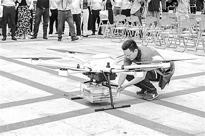 郵政工作人員取出無人機(jī)配送的高考錄取通知書。華南理工大學(xué)供圖