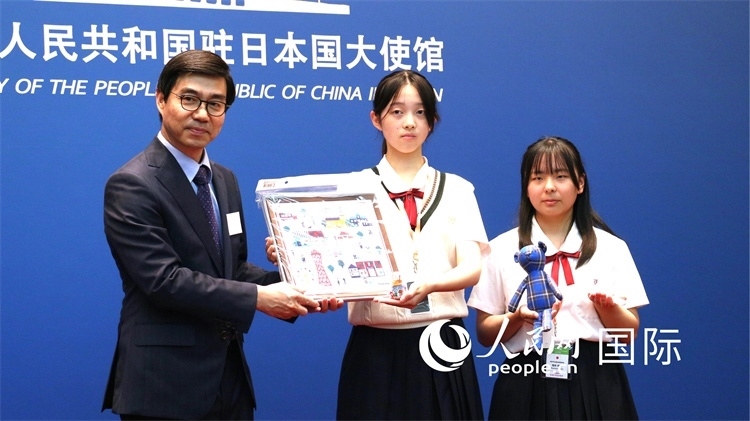 日本小大使向中國(guó)駐日本大使館臨時(shí)代辦施泳贈(zèng)送當(dāng)?shù)靥厣Y品。人民網(wǎng) 許可攝