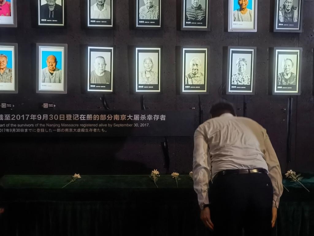 7月18日，人們向離世的南京大屠殺幸存者獻(xiàn)花、鞠躬。新華社記者邱冰清 攝