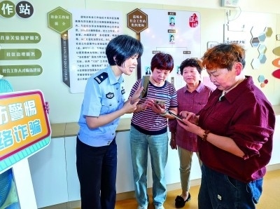 浙江湖州民警指導(dǎo)居民加入湖州“e企安”微信群，實(shí)時(shí)接收反詐信息。新華社發(fā)