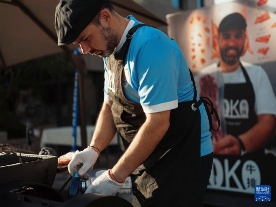 7月19日，在蕪湖古城，馬丁在當(dāng)天舉行的啤酒節(jié)上制作牛排。新華社發(fā)（繆雨晨 攝）