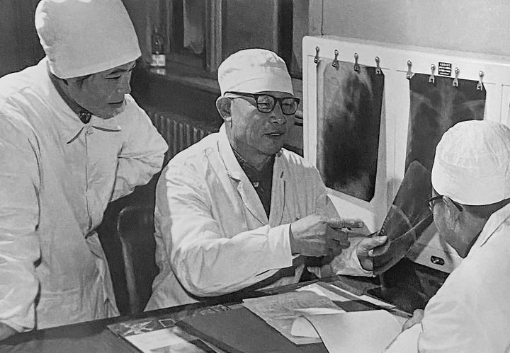 1980年1月16日，中日友好醫(yī)院首任院長辛育齡（中）在內(nèi)蒙古結(jié)核病院與胸外科醫(yī)師討論病例（翻拍照片）。 新華社發(fā)