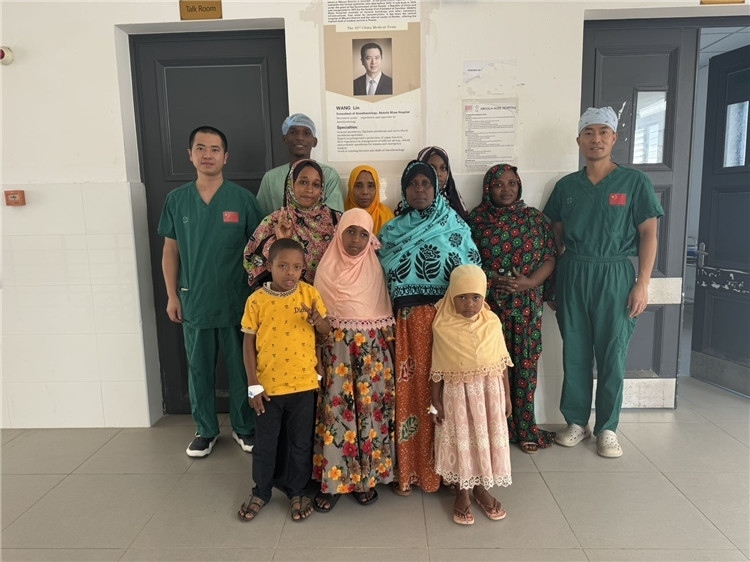 李廣（右一）和王林醫(yī)生與部分患者合影。中國援桑醫(yī)療隊(duì)供圖