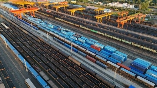 這是2024年8月14日在黑龍江綏芬河鐵路口岸集裝箱換裝場拍攝的集裝箱換裝作業(yè)現(xiàn)場（無人機照片）。今年前七個月，綏芬河鐵路口岸開行中歐班列573列，運量達55246標箱，同比分別增長23%和18%，班列數(shù)量持續(xù)保持高位運行。