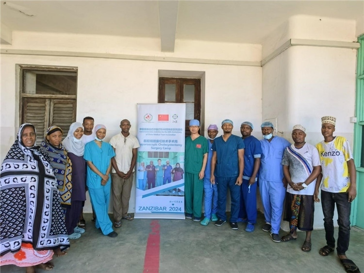 隊(duì)長(zhǎng)蔣國(guó)慶（右七）和手術(shù)醫(yī)生、部分患者合影。中國(guó)援桑醫(yī)療隊(duì)供圖