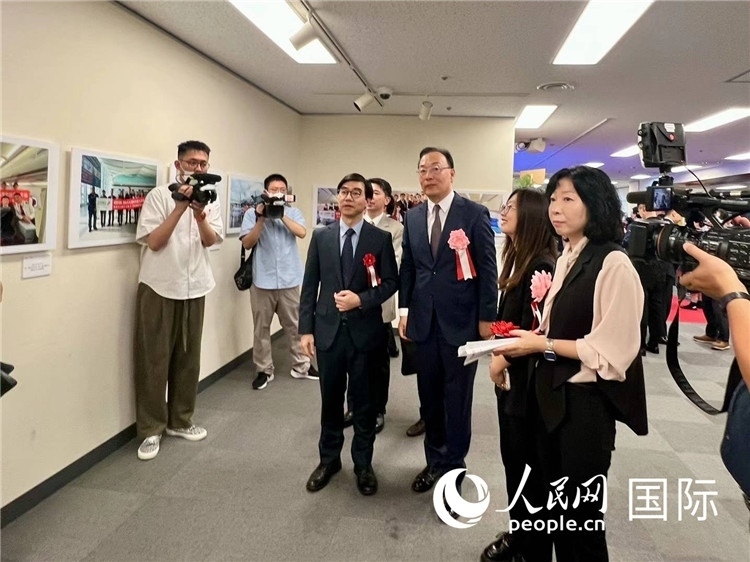 中國國際航空日韓地區(qū)支社支社長馮力為中國駐日本大使館臨時代辦施泳等嘉賓介紹展出圖片。人民網(wǎng) 許可攝
