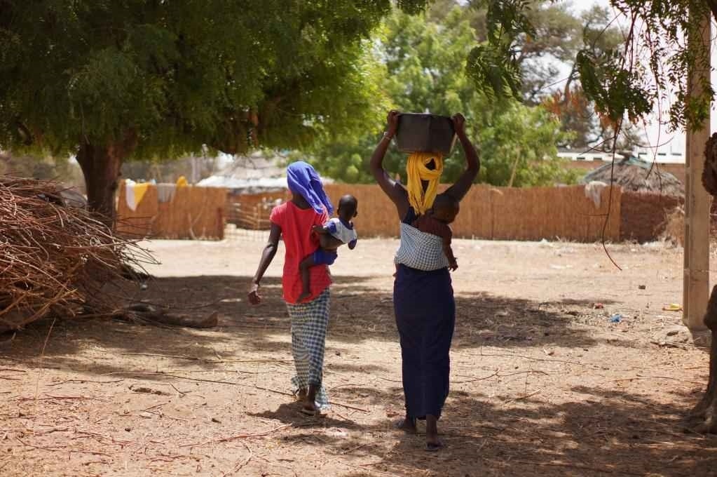 2023年3月20日，在塞內(nèi)加爾久爾貝勒區(qū)的泰內(nèi)富勒村，村民將取到的水運回家。新華社記者 王子正 攝