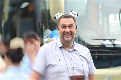 參訪熊貓谷前，塞爾維亞“一帶一路”研究所所長博揚(yáng)·拉利奇戴上熊貓頭飾。（李佩藺 攝）