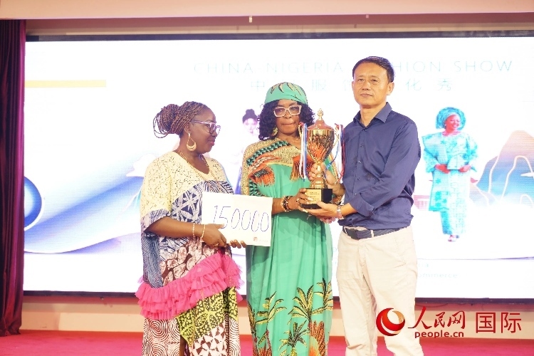 中國駐尼日利亞使館文化參贊兼中國文化中心主任李旭大（右）為最佳表現(xiàn)獎頒獎（中）。人民網記者 姜宣攝