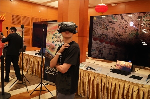 1、在本次活動(dòng)的展覽現(xiàn)場(chǎng)，敦煌研究院與騰訊展示了“數(shù)字藏經(jīng)洞”和“尋境敦煌”等創(chuàng)新互動(dòng)產(chǎn)品。圖為當(dāng)?shù)孛癖娡ㄟ^(guò)VR虛擬游覽洞窟。 人民網(wǎng)記者 李志偉攝