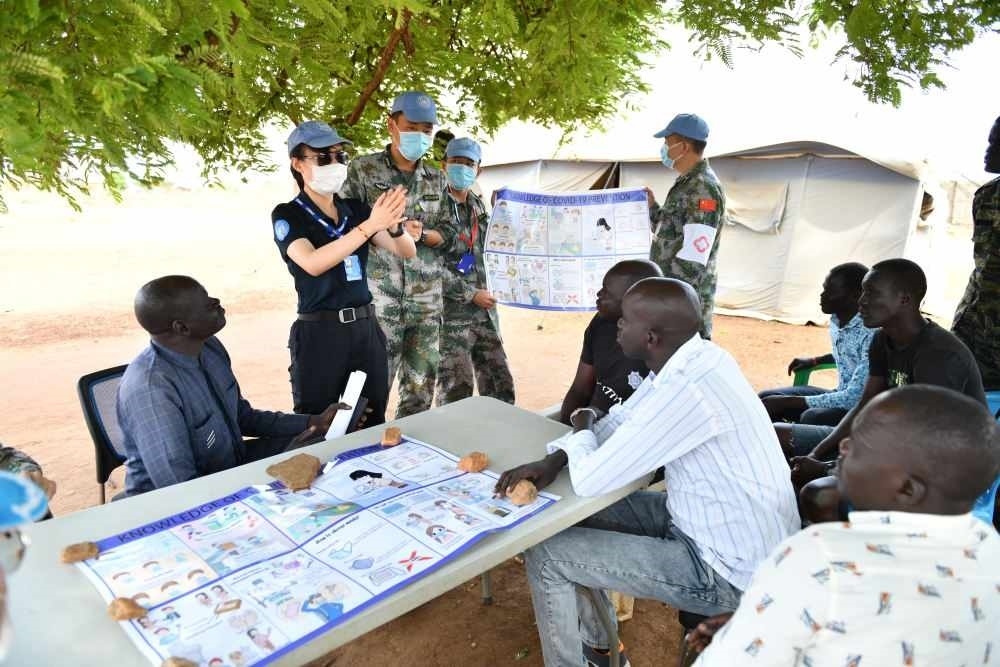 2020年3月，在南蘇丹首都朱巴，執(zhí)行聯(lián)合國維和任務(wù)的中國維和警察廖潔給當(dāng)?shù)鼐熘v解防疫知識。