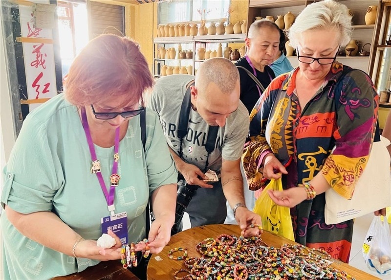 歐亞媒體考察團成員在母氏陶藝館內(nèi)挑花了眼，色彩絢麗、質(zhì)地均勻的陶藝手串讓他們愛不釋手。“這里的東西都太實惠了！”塔吉克斯坦《索格特真理報》政論部主任娜塔利婭·多羅費耶娃說?；宓奶厣a(chǎn)品物美價廉，讓考察團成員為家人好友買到了心儀的禮物，也為此次以四川成都為起點，路經(jīng)南充、廣安至貴州遵義的考察行程畫上了圓滿句號。（張亞欣攝）