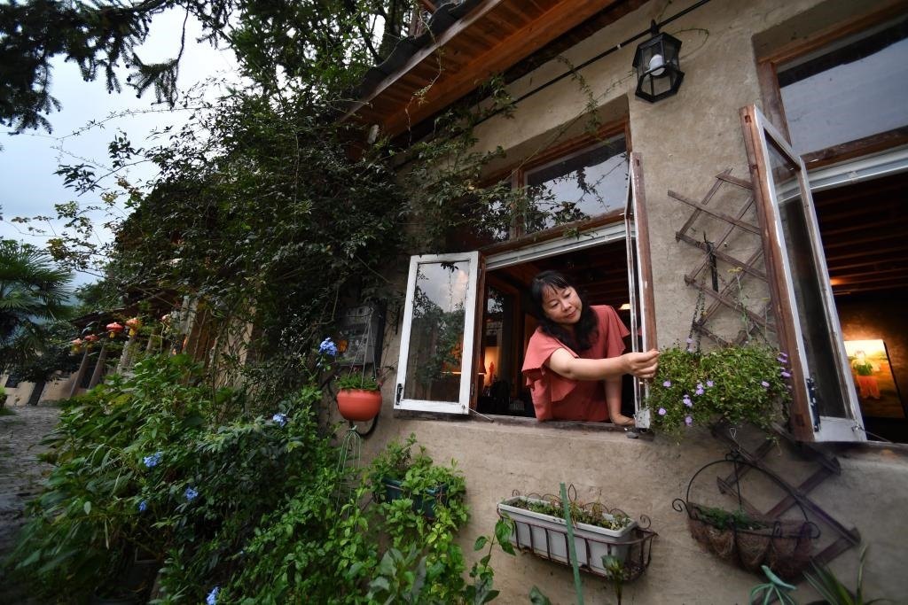 8月29日，在福建省屏南縣熙嶺鄉(xiāng)，龍?zhí)洞濉靶麓迕瘛泵泛暝诖蚶碜约航?jīng)營(yíng)的民宿外墻裝飾花盆。新華社記者姜克紅 攝