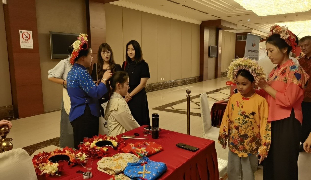 阿拉扎大學(xué)孔子學(xué)院志愿者老師向傳承人學(xué)習(xí)簪花圍。阿拉扎大學(xué)孔子學(xué)院供圖