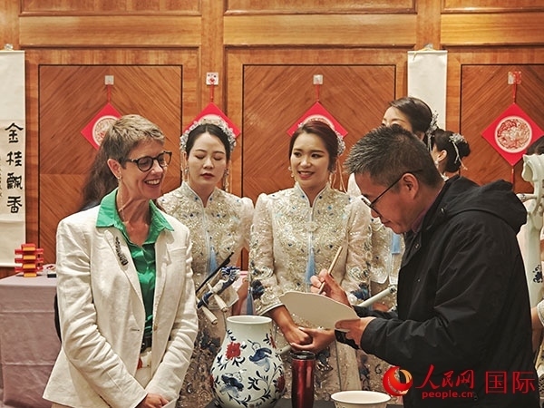 現(xiàn)場的非遺傳承人為英國觀眾展示畫技。人民網(wǎng)記者 邢雪攝