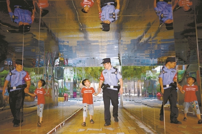 ?7月16日，重慶市公安局江北區(qū)分局一名民警在巡邏途中遇到一個獨自玩耍的小男孩，民警將其送回家。王洪平攝