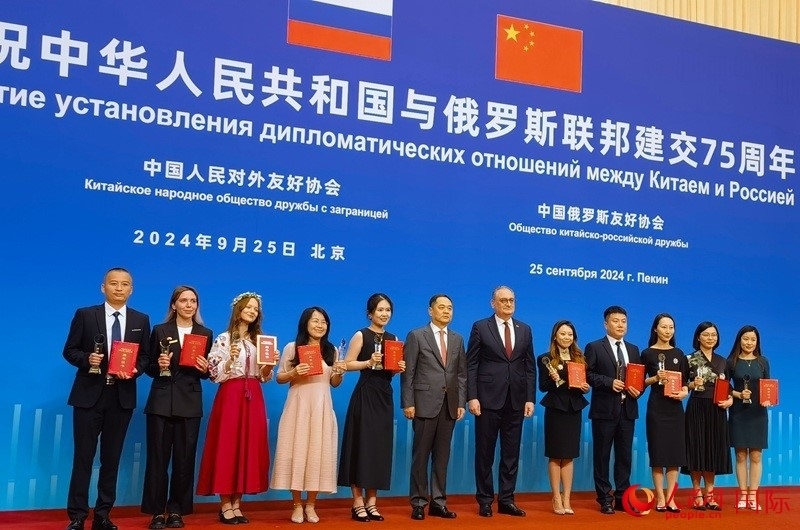 楊萬明會長和莫爾古洛夫大使為10位中俄青年友好微視頻創(chuàng)意大賽獲獎代表頒獎。人民網(wǎng)記者 李明琪攝