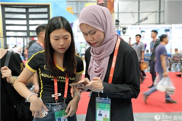 東博會現(xiàn)場，馬來西亞展商在同中方工作人員交談。人民網(wǎng)記者 趙益普攝