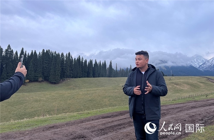 在庫爾德寧，吾買爾江被雪山美景震撼，即興錄制了短視頻作品。人民網(wǎng)記者曾書柔攝