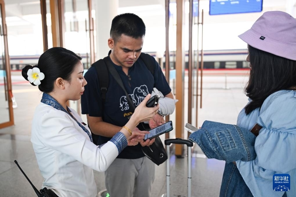 10月12日，在老撾萬(wàn)象中老鐵路萬(wàn)象站，工作人員檢驗(yàn)乘客車票。新華社記者 程一恒 攝