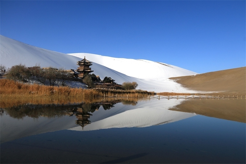 鳴沙山月牙泉景區(qū)雪景。敦煌市委宣傳部供圖，張曉亮攝