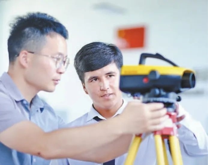 在塔吉克斯坦首都杜尚別的魯班工坊，來自天津城市建設(shè)管理職業(yè)技術(shù)學(xué)院的老師（左）為當(dāng)?shù)貙W(xué)生提供指導(dǎo)。新華社記者 鄭開君 攝