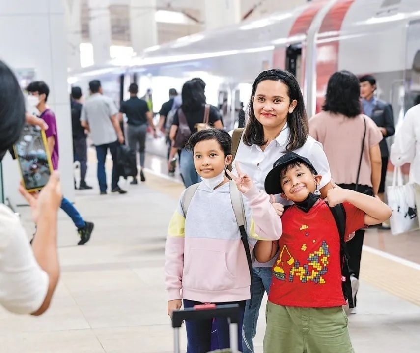 雅萬高鐵是我國在境外完成全過程勘察設(shè)計建設(shè)的首個高鐵項目，于去年10月17日正式開通運營，是中印尼共建“一帶一路”合作的典范。圖為乘客在和雅萬高鐵動車組合影留念。新華社記者 徐欽 攝