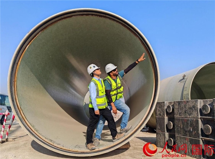 工作人員在察看輸水管情況。人民網(wǎng)記者 管克江攝