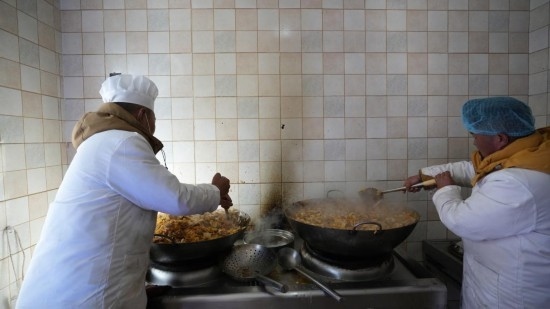 1月14日，服務(wù)隊的兩名廚師正在為村民們做午飯。新華社記者 邱星翔 攝