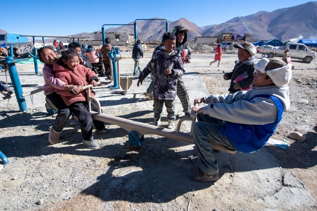1月11日，在定日縣措果鄉(xiāng)塘仁村安置點(diǎn)，西藏星光社會工作服務(wù)中心志愿者和孩子們一起玩耍，進(jìn)行災(zāi)后心理疏導(dǎo)。人民網(wǎng)記者 翁奇羽攝