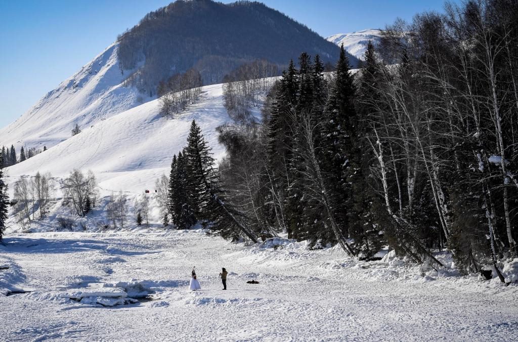 2024年2月5日，兩名游客在新疆阿勒泰地區(qū)布爾津縣禾木村拍照。新華社記者 馬鍇 攝