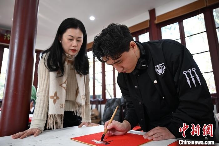 1月20日，外籍留學(xué)生在西泠印社社員李硯指導(dǎo)下寫福。當(dāng)日，來自巴西、馬來西亞、加納、哈薩克斯坦的外籍留學(xué)生在浙江杭州西泠印社體驗福貼、春聯(lián)和篆刻，感受古老的中國傳統(tǒng)文化。中新社記者 王剛 攝
