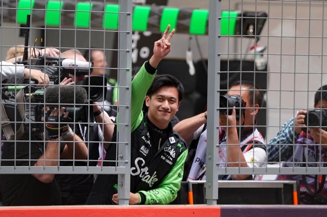 2024年4月19日，索伯車隊(duì)中國(guó)車手周冠宇（中）在練習(xí)賽前向觀眾致意。當(dāng)日，F(xiàn)1中國(guó)大獎(jiǎng)賽在上海開賽。中國(guó)車手周冠宇主場(chǎng)首秀參賽。新華社記者 夏一方攝