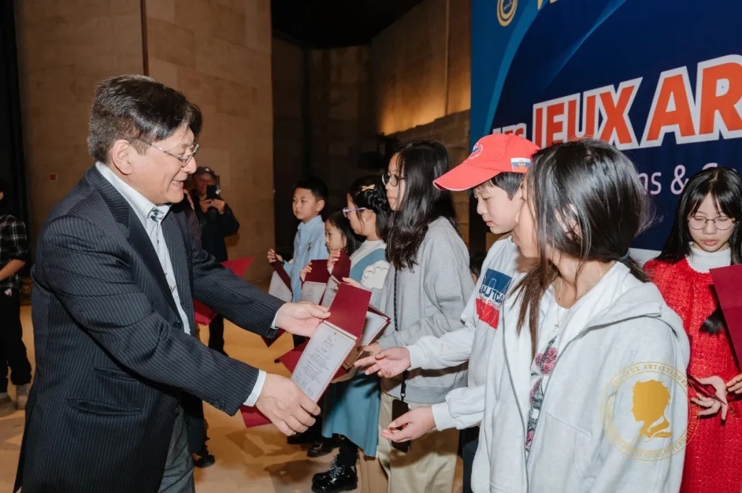 圖2：亞丁為獲獎兒童頒發(fā)證書。法中交流促進(jìn)會供圖