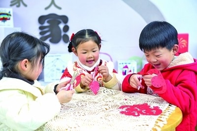 圖為孩子們?cè)诶蠋熤笇?dǎo)下制作蛇年主題剪紙。 新華社記者 徐昱攝