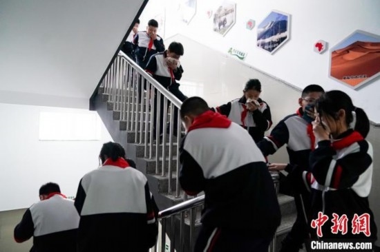  圖為學(xué)生們進(jìn)行應(yīng)急疏散演練。中新社記者 趙宇航 攝